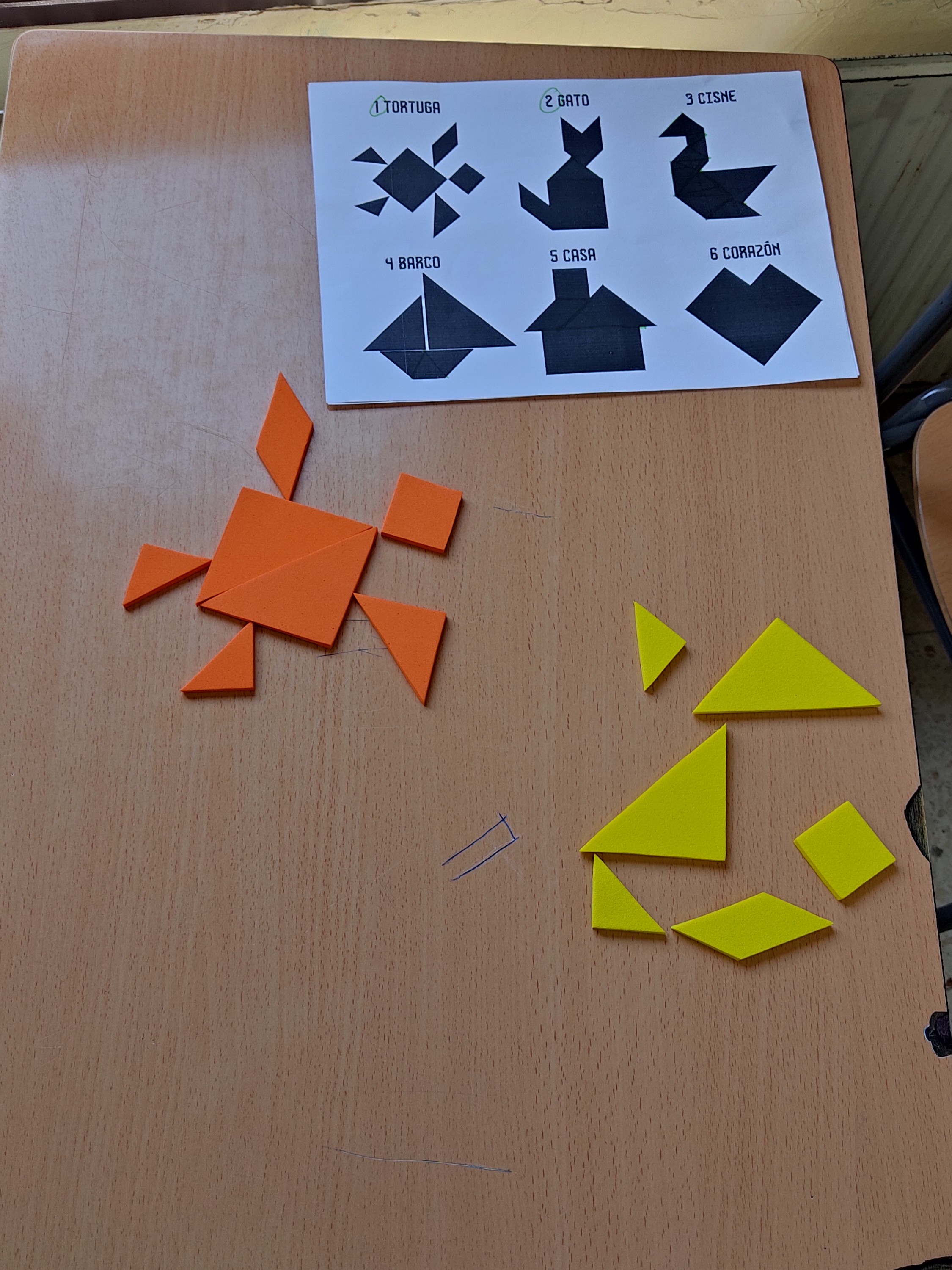 Siete piezas geométricas del Tangram (triángulos de distintos tamaños, un cuadrado y un paralelogramo) formando la silueta de una casa
